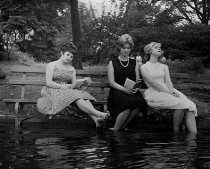 Three women keep cool during a heat wave by moving a park bench into the water in Central Park New York.jpg